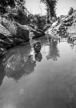 A man takes a bath in a spring in the Gorongosa mountains.