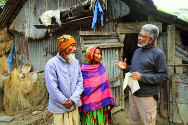 Rafiqul Alam, an anti-povery activist who runs the NGO Dwip Unnayan Songstha (DUS), meeting with Shah Alamgir and his wife Khodeja in front of their house. Alam is helping them secure the rights to th...