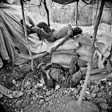Men at an informal mine sleep during a break.