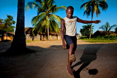 A youth plays football with a coconut.