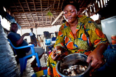 A woman holds a bowl of grubs, a speciality food of the region.