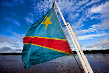 The flag of the Democratic Republic of Congo flies from the stern of a boat on the River Congo.