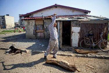 A man chops wood in a Roma settlement in 'Budulovska Street', where around 800 Roma live in a segregated settlement.