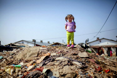 A child stands on a mound of debris in a Roma settlement located on 'Budulovska Street', a segregated settlement where around 800 people live.
