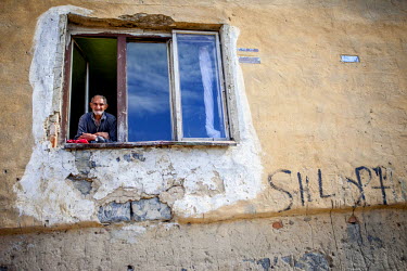 Jan Ondic, 87, one of the oldest inhabitants in the Roma settlement of Podsadek, looks out from a window.