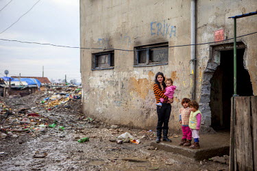A young mother with her child in front of a decrepit building in the Roma settlement on 'Budulovska Street', a segregated community where around 800 people live,