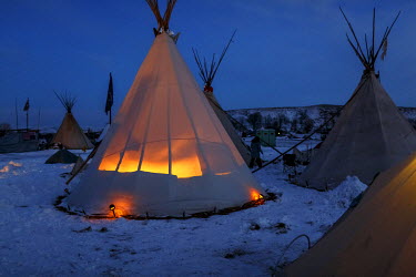 A light illuminates a teepee (tipi) at the Oceti Sakowin Camp, one of several camps housing protestors fighting the planned Dakota Access Pipeline (DAPL).  In April 2016 the Standing Rock Sioux Tribe...