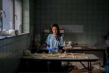 Victoria Amina-Dautovic, a staff member at an International Commission on Missing Persons (ICMP) mortuary facility, trains using a synthetic skeleton.
