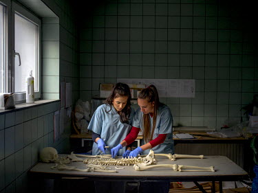 Victoria Amina-Dautovic (left) and Bojana Tomasevic, staff at an International Commission on Missing Persons (ICMP) mortuary facility, train using a synthetic skeleton.