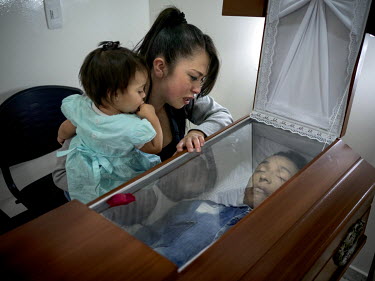 Nasly Martinez, 19, stands beside the coffin containing the dead body of Alvaro Steven, the father of her one year old daughter Sharid Popayan. Described as ‘caring and funny’, the 20 year old fat...