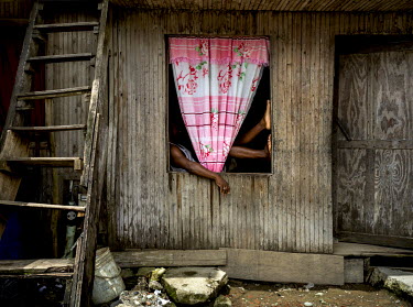 A man sits in the window of a house in Puente Nayero, a slum area home to more than 1200 families. An estimated 95 percent of the residents have been forcibly displaced from their original homes due t...