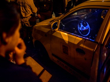 Police and onlookers gather around a taxi which is stained with its driver's blood who was murdered in what was assumed to be an act of 'ajuste de cuentas' (violent street justice), in this case punis...