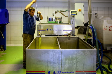 An employee at an olive oil factory in Palaiochora operates a machine during the pressing process.