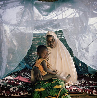 Ramatou Inoussa, 19, and her baby Oumarou, two, at her grandmother's house where they live as her parents died when she was young. She never went to school. She says: 'On a normal day I clean the hous...