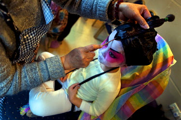Yan-Ting, 4, from Cha Duk Chang, the Children's Cantonese Opera Association of Hong Kong, has her wig fixed backstage. Unlike many performance groups now using synthetic wigs, real hair is used here i...