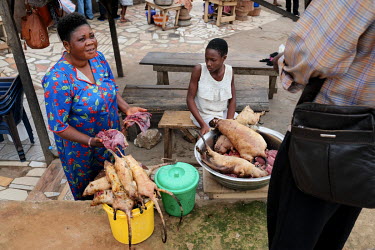 Adwoh Serwaa, a bushmeat vendor, selling grasscutters (greater cane rat) and giant rats to a customer at Atwemonom, the city's main bushmeat market. Bushmeat is a delicacy in Ghana, but there are conc...