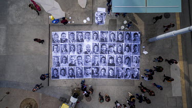 Portraits of refugees pasted onto the ground at a busy intersection in the Plainpalais district of Geneva. The portraits are of people from various countries including Syria, Eritrea Afghanistan Iraq,...