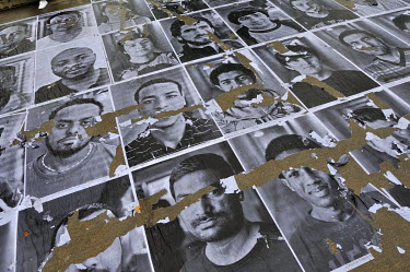 Defaced ortraits of refugees pasted onto the ground at a busy intersection in the Plainpalais district of Geneva. The portraits are of people from various countries including Syria, Eritrea Afghanista...