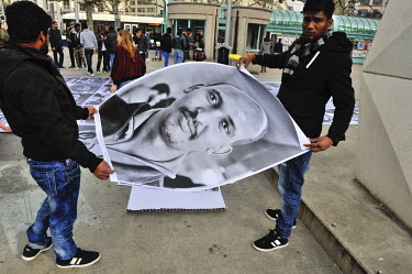 A group of asylum seekers paste portraits of refugees onto the ground at a busy intersection in the Plainpalais district of Geneva. The portraits are of people from various countries including Syria,...