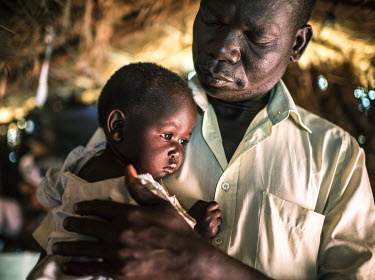 Joseph Malis, 39, with his daughter in his shelter in Bidibidi refugee camp. Malis fled his home in Gimono village, South Sudan, after government soldiers burned it down killing three people in August...