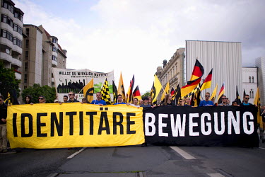 Supporters of the right-wing youth organisation Identitaere Bewegung holding a giant banner and waving flags at a rally. Identitaere Bewegung is against the so-called Islamification of the West, and i...
