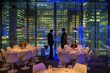 Businessmen look out from the Plateau Restaurant at Canary Wharf.