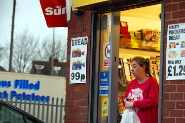 A woman leaves a newsagent's shop in the city centre.
