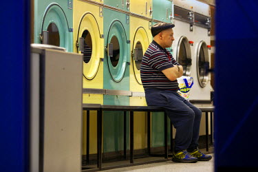 A man waits for his washing at a launderette in the Hanley area of the city.