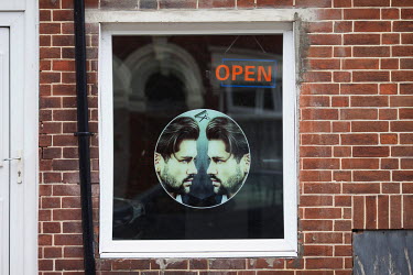 A sign in the window of a barber's shop in the city centre.