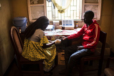 Herman (r) gets tested for HIV at the PODI Ouest. The PODIs, which are run by the RNOAC (Reseau national des organisations d'assises communautaires) group of people with HIV, offers testing, support a...