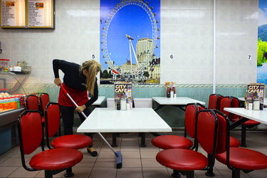 A woman sweeps the floor in the City Cafe in the city centre where you can get a classic all day breakfast with toast and tea for GBP 2.99.