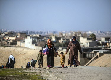 Civilians flee across no man's land from a village held by ISIS towards the Iraqi army's front line at Albu Saif. In February Iraqi troops launched a long awaited operation to liberate West Mosul, whi...