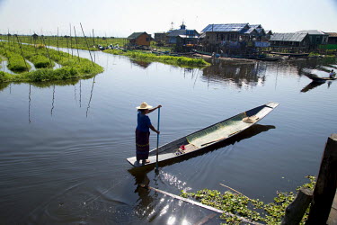 A woman paddles a canoe along one of the waterways in the Lake Inle region.