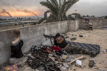 Snipers with the Iraqi army's Emergency Response Unit hunkered down on a rooftop position in east Mosul, exchange fire across the Tigris River with ISIS militants, who still control the majority of we...