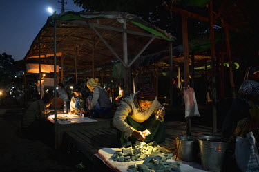 Jade traders use their torches to assess the quality of jade being sold outside the Mandalay Jade Market.