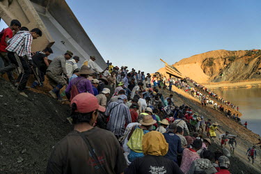 Freelance miners scavenge for jade rocks as the discarded tailings from Kayin Gyaung Jade Mine are dumpedfrom trucks. Kayin Gyaung Jade Mine is owned by Hong Pang Company which is owned by Wei Hsue Ka...