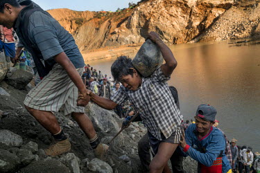Freelance miners scavenge for jade rocks as the discarded tailings from Kayin Gyaung Jade Mine are dumpedfrom trucks. Kayin Gyaung Jade Mine is owned by Hong Pang Company which is owned by Wei Hsue Ka...
