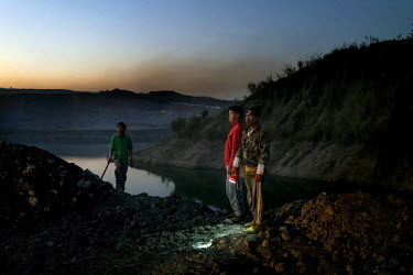 Freelance miners wait to scavenge for jade rocks in the discarded tailings from Hmaw Si Sar Mine.