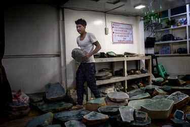 A worker carries a jade rock in a jade company showroom, near the Mandalay Jade Market. Most of the jade from Myanmar is purchased by Chinese dealers and taken back to be sold in China for large profi...