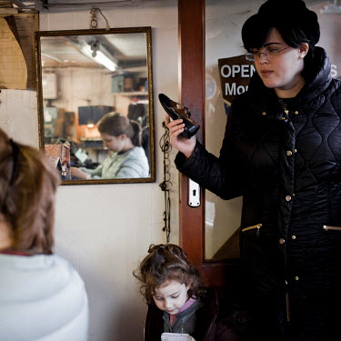 A woman and her child at the Semos shoe repair shop in Stamford Hill.