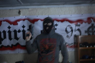 A member of the National Socialist group KNS (Committee for Nation and Freedom) with a handgun at the KNS clubhouse in a Moscow suburb, where members also workout, train with knives and hold discussio...