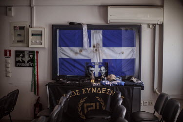 A Greek flag forms a memorial to two members gunned down in 2013 in the offices of the fascist Golden Dawn.