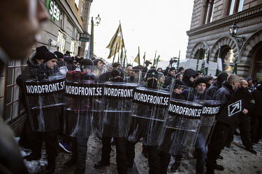 Members of the Nordic Resistance Movement, carrying riot shields and flags, bearing a quasi-fascist symbol, confront anti-fascist protestors near Royal Palace. Around 600 members and supporters attended the event organised by the right-wing extremists.  'Our most important issue is the survival of the people', says Haakon Forwald, a Norwegian who emigrated to Sweden and is now leader of the Norwegian Nordic Resistance Movement.