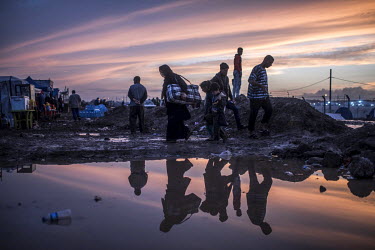 People displaced by fighting between government forces and ISIS militants in Mosul walk along a muddy path near the Hamam al Alil IDP camp ten kilometres south of the city.