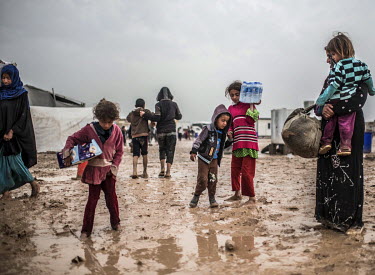 Women and children displaced by fighting in Mosul arrive at a muddy IDP camp in Hamam al Alil, ten kilometres south of the city.