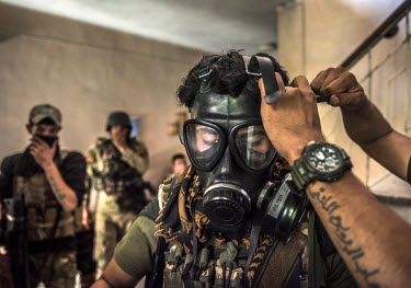 A soldier puts on a gas mask after they were hit by an unidentified gas during heavy fighting with ISIS militants on the front line in the al Thawra neighbourhood of western Mosul.