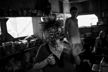 39 year old Connie smoking a joint while dancing in her kitchen. She says she was sexually assaulted by adults as a child and has been living in Slab City, a squatters' camp about 190 miles southeast...