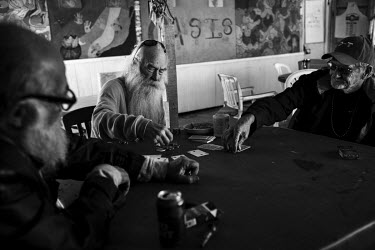 Three elderly men playing poker at the Oasis Cafe in Slab City, a squatters' camp about 190 miles southeast of Los Angeles.  Slab City, known as The Slabs, is named for its areas of concrete where for...