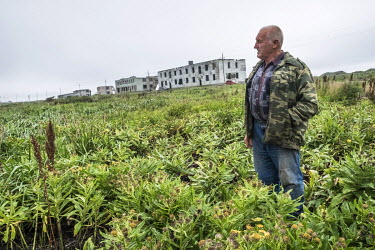 Eugeny Kalitin (75) standing in a field near the so-called 2nd Base in Oktyabrsky, an area heavily affected by costal erosion, where he used to live until the mid 1970s. When the houses collapsed, he...