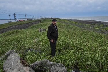 A local activist Konstantin Lavrov, 42, standing in the centre of the Oktyabrskiy sandbar.  Since the 1970s the sea has been claiming the land, destroying part of the settlement. Almost three entire s...